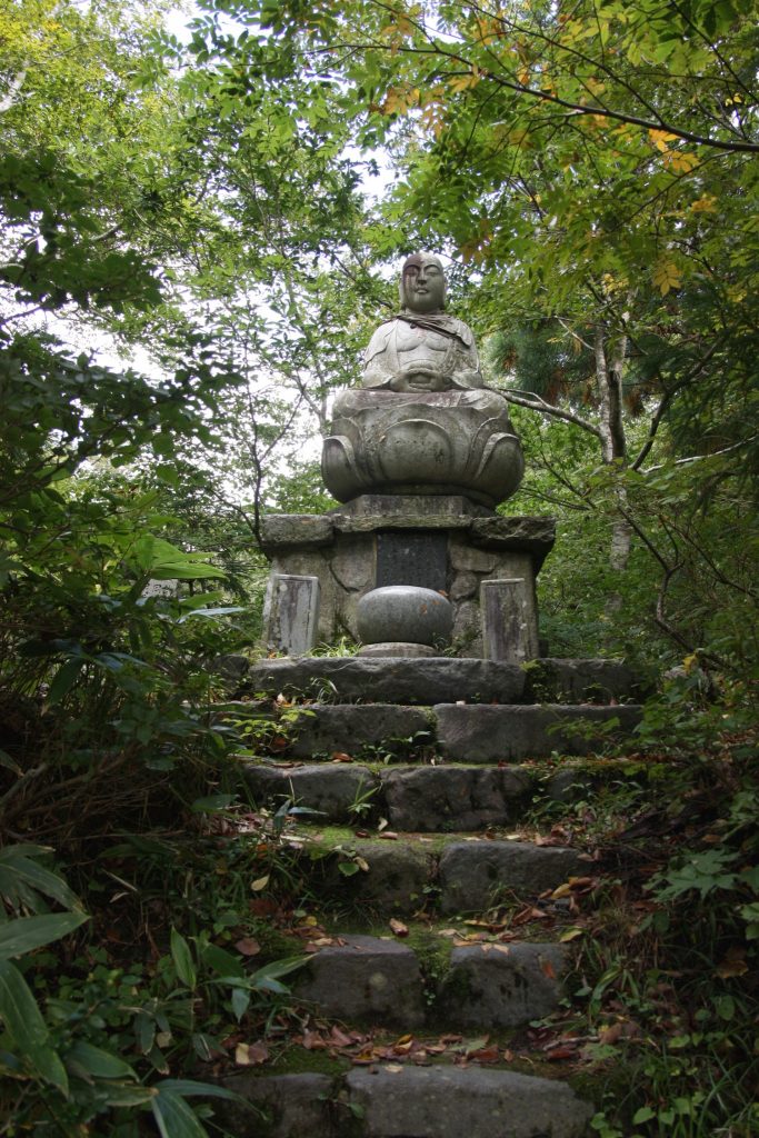 Steinstatue in einem japanischen Wald.