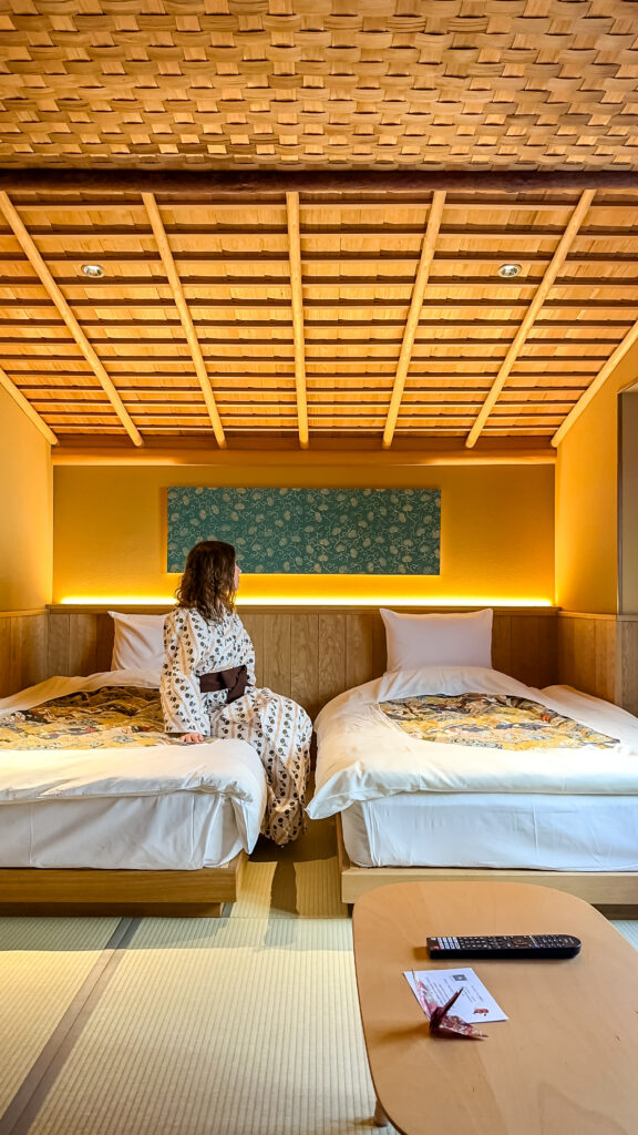 Una chica setnada en una cama del ryokan en Kioto