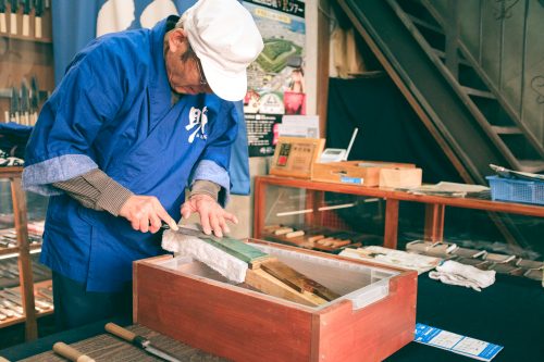 Artisan mending a blade on a water stone, Wada shop, Sakai, Osaka, Japan
