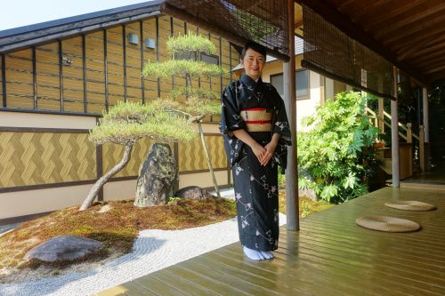 A staff member in kimono greets guests at Ryokan Shinsen in Takachiho.