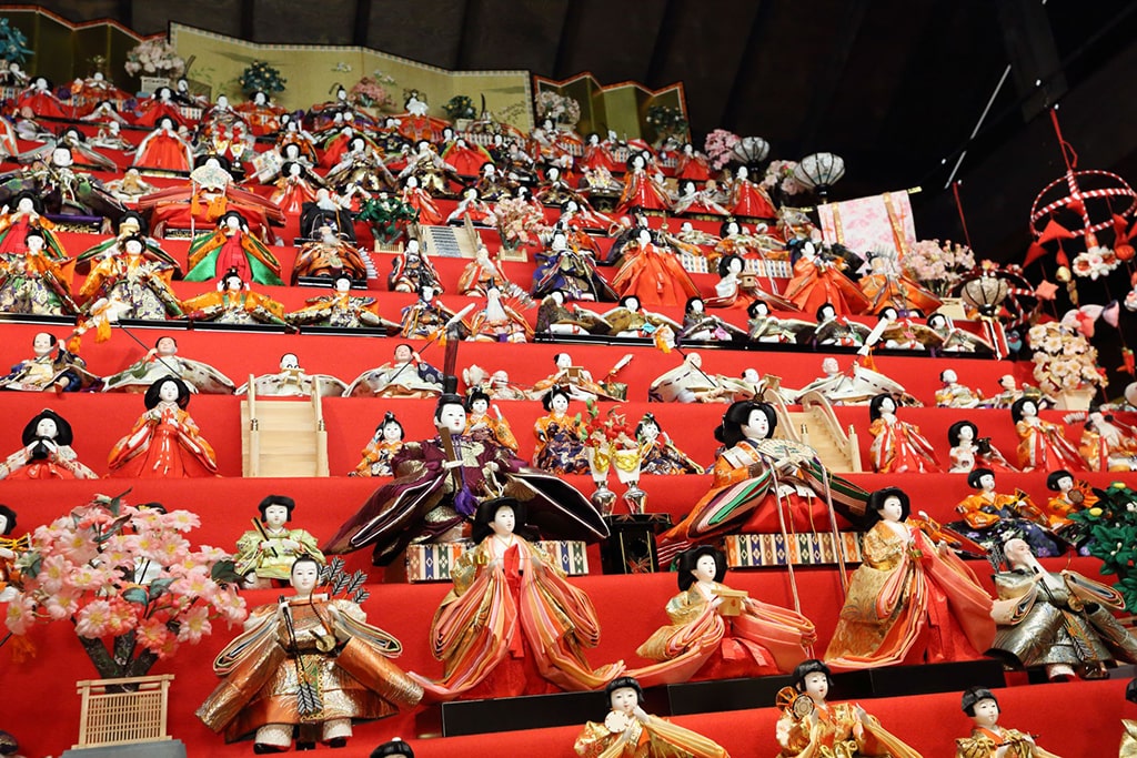 Esposizione di bambole tradizionali per il giorno delle bambine sulle scale rosseーDue modi diversi per esporre le bambole per l’Hina Matsuri: dalla semplice coppia imperiale a un set completo di bambole.