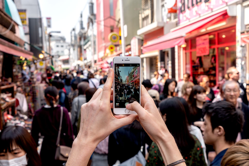 Turista che fotografa con lo smartphone in Giappone