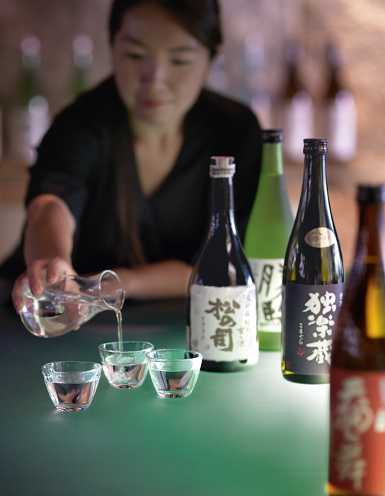 Sake is being poured into small sake glasses called ochoko. Different types of sake reflect the various climates and seasons of Japan.