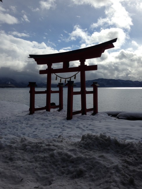 Tori gate right on the beach of snow before the water.