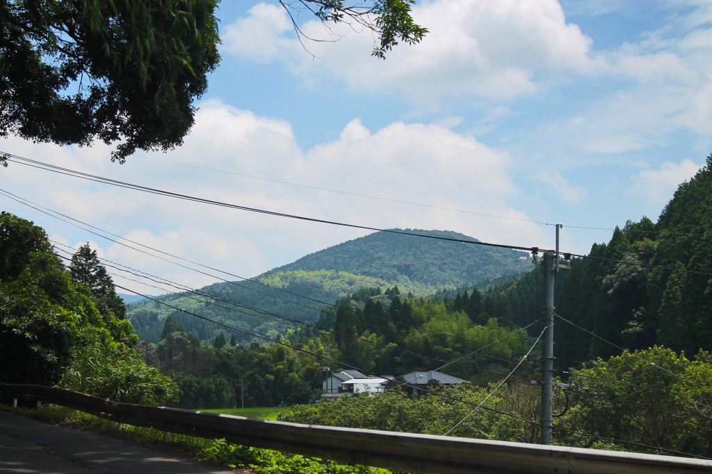 Mountain full of trees and a house on the way to Kirishima Jingu Shrine.