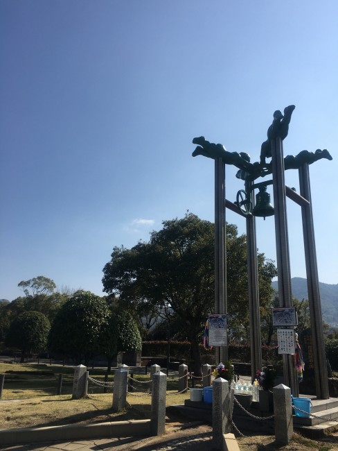 Bell that has a design of four baby angels holding it at Nagasaki Peace Park.
