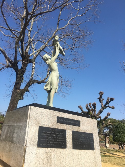 Statue of a woman raising her child up in the air at Nagasaki Peace Park.