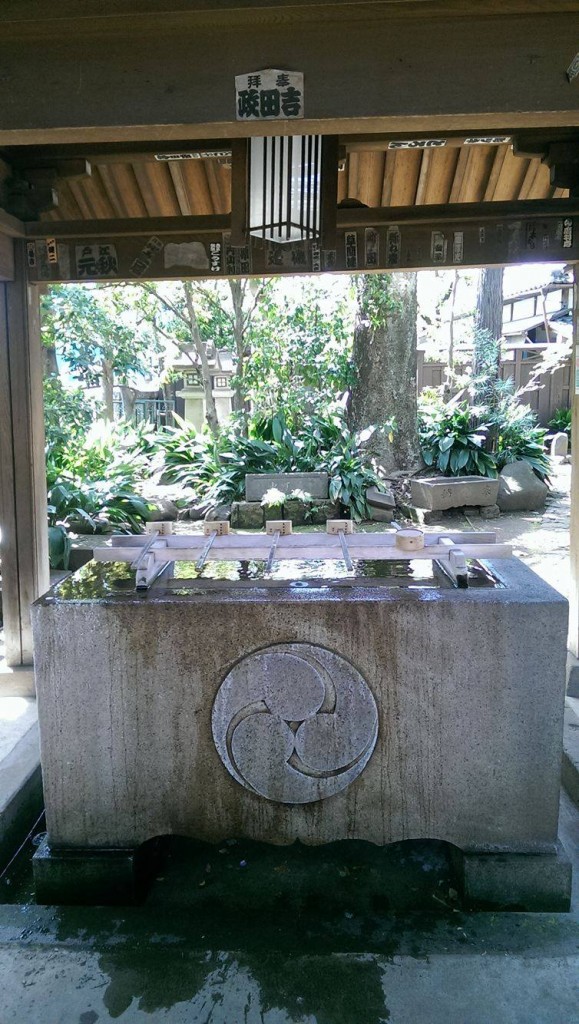 Cleansing station at Okusawa shrine gate in Tokyo.