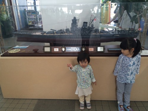 children pose next to a ship model in Kaiwomaru Park in Japan