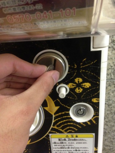 Inserting the 100 yen into the machine.